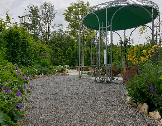 schaugarten mit Steinweg und einer luftigen Pergola