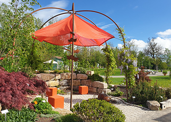 Garten mit Sonnenschutz und einer kleinen Natursteinmauer