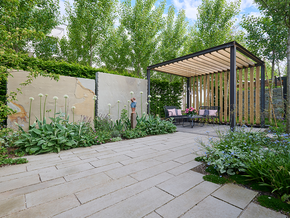 Sichtschutz durch Bäume; Pergola mit Holzelementen und Sitzplatzmöglichkeiten