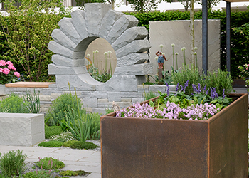 Runde Steinskulptur als Hingucker im Garten